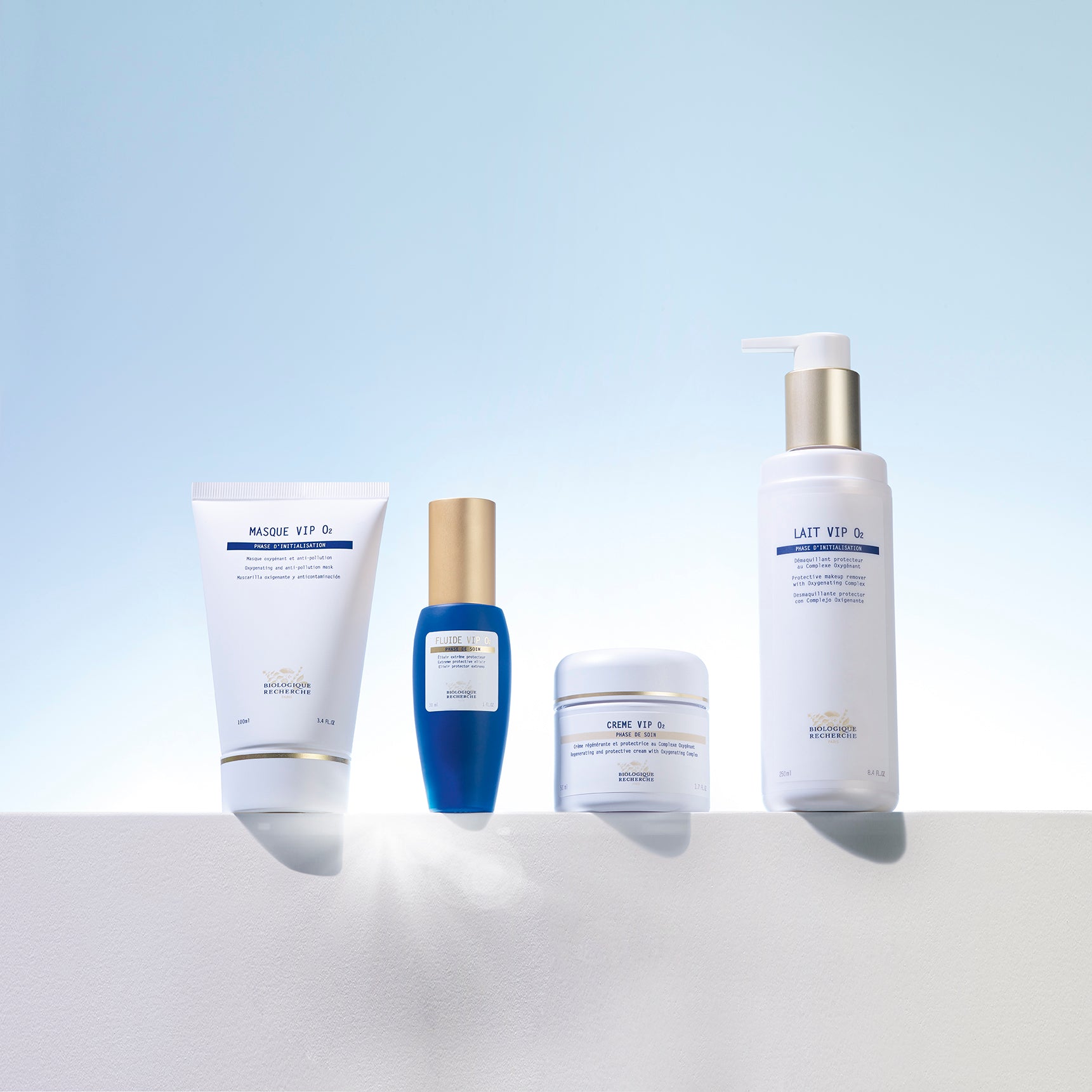 Four Biologique Recherche skincare products including white tube, blue dropper bottle, white jar, and white pump bottle on.