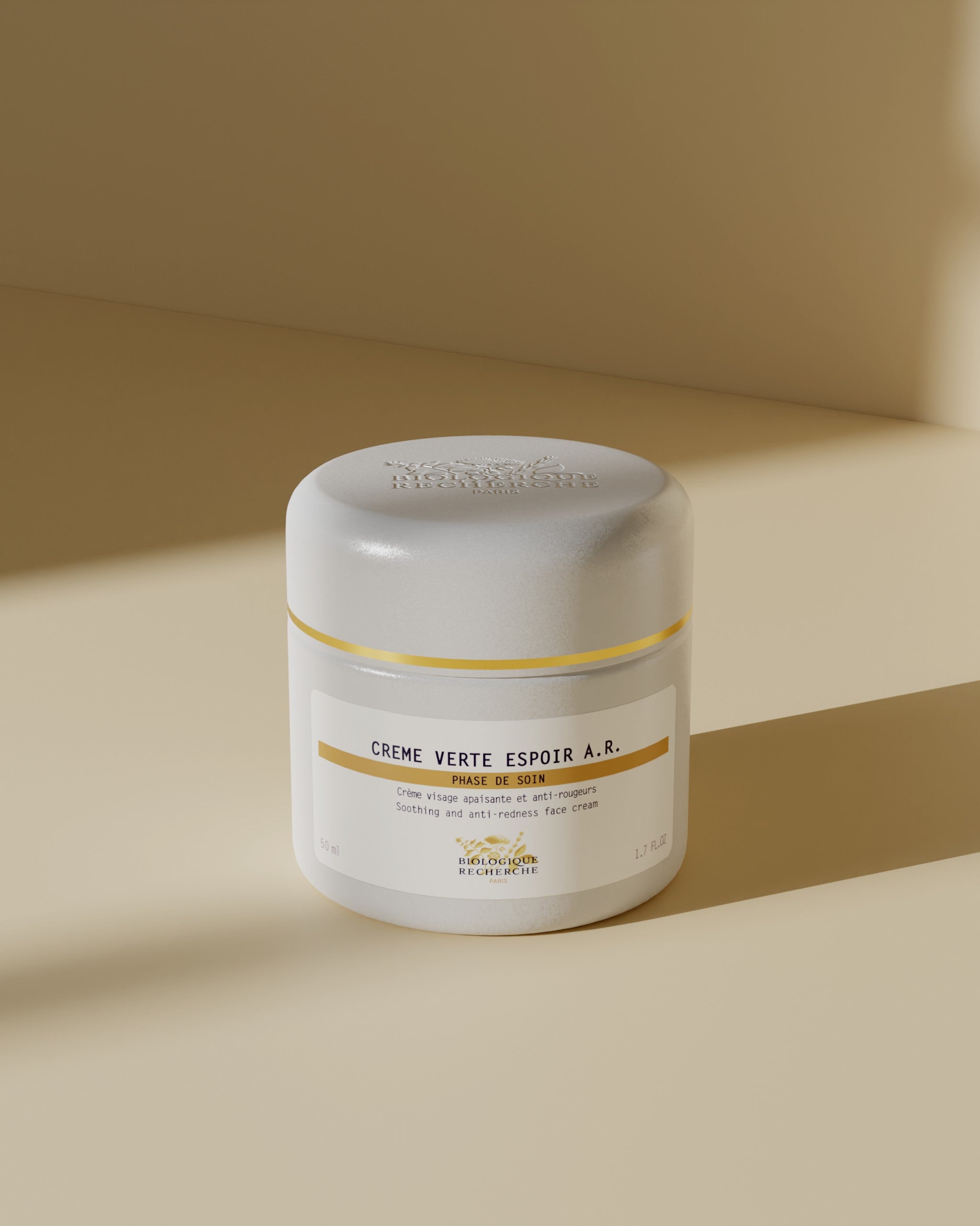 White jar of Crème Verte Espoir A.R. moisturizer with yellow and gray label on beige background.