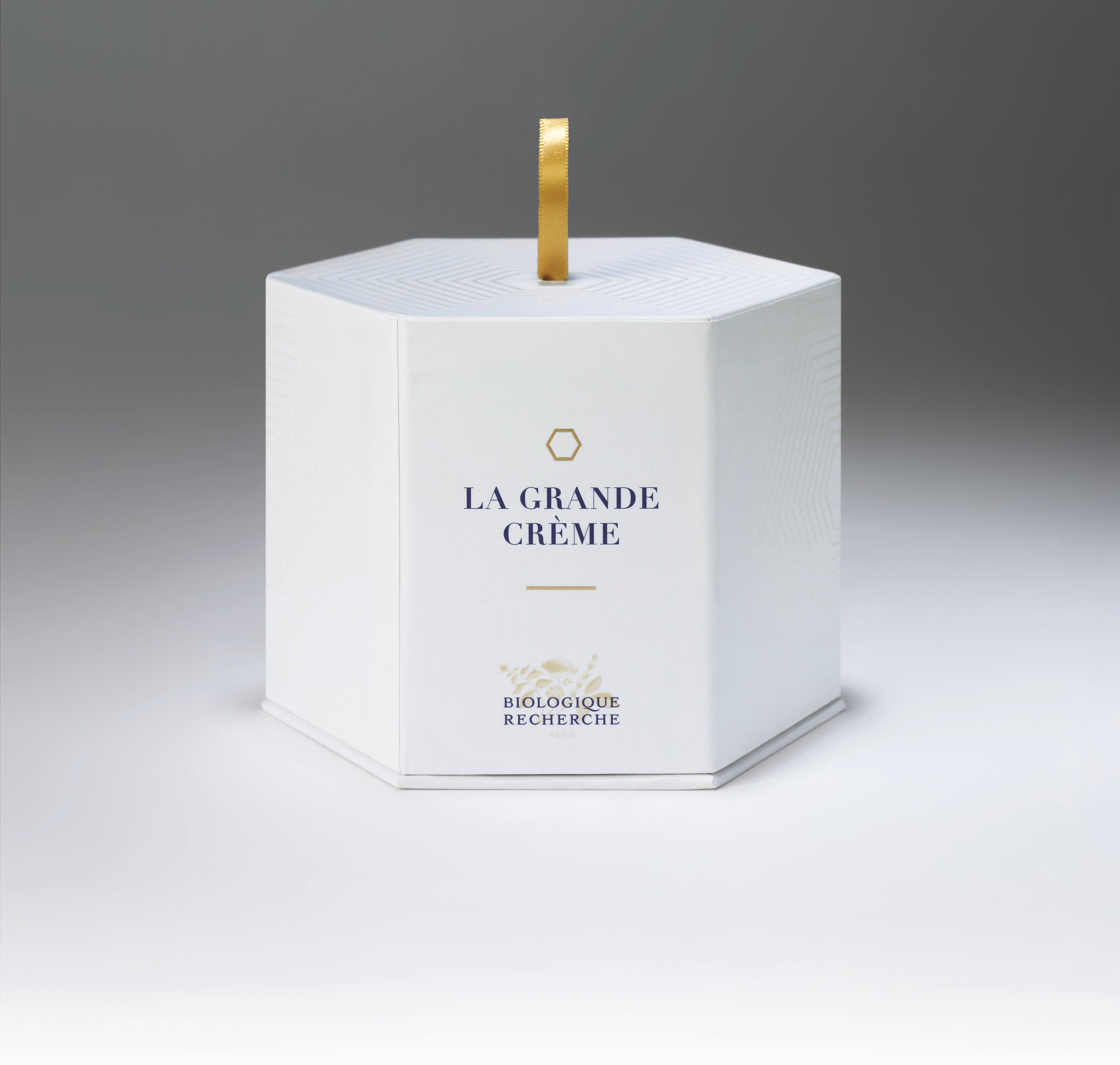 White hexagonal box with gold handle labeled La Grande Crème by Biologique Recherche.