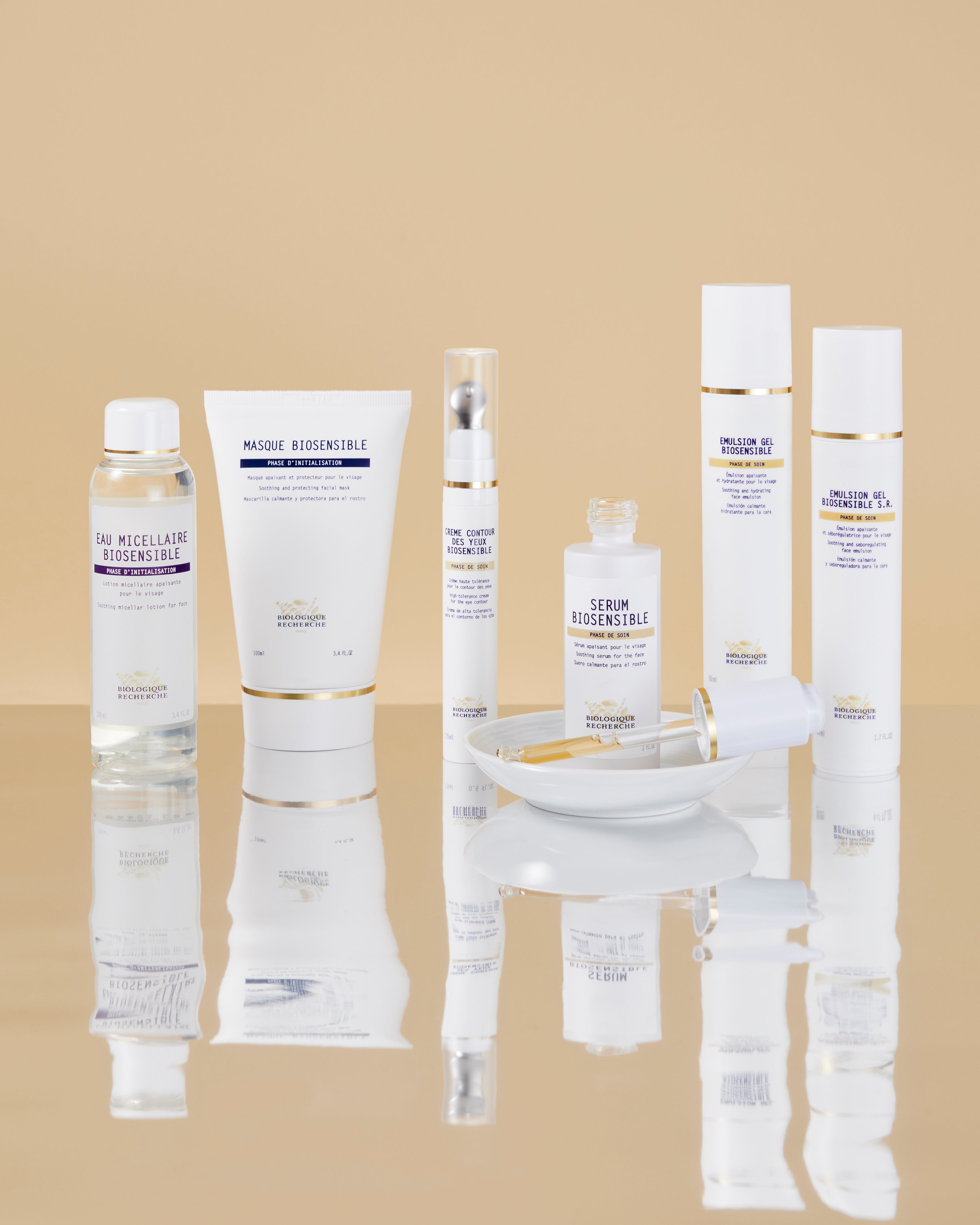 Set of seven Biologique Recherche skincare products including Eau Micellaire Biosensible in clear, white, and purple.