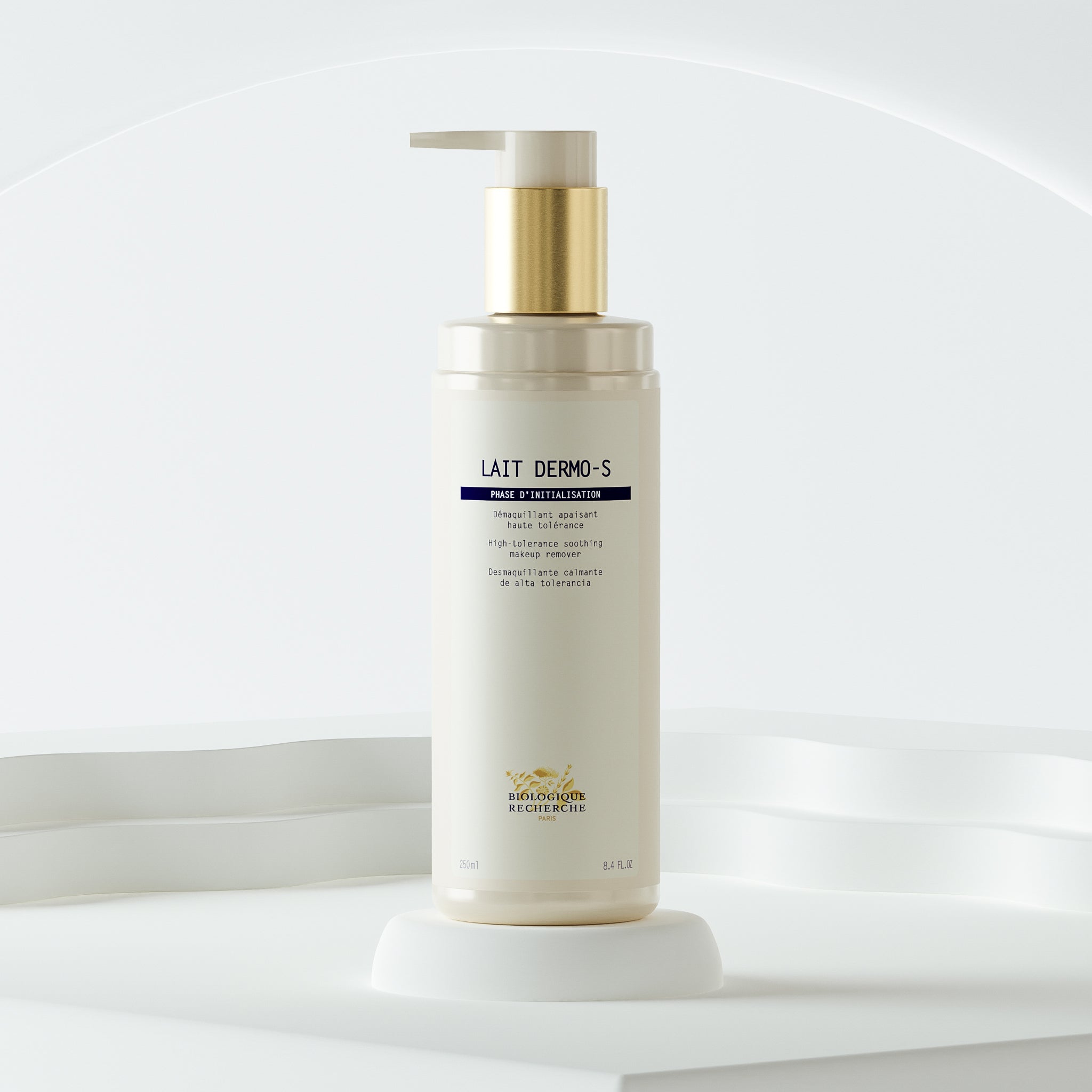 White pump bottle of Lait Dermo-S skincare cream with gold accents on white pedestal.