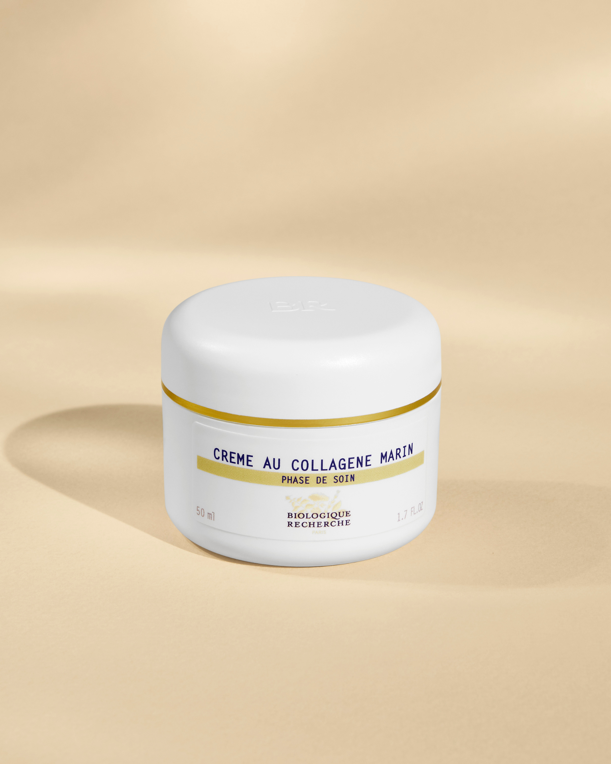 White jar of Crème Au Collagène Max in yellow and black text on a beige background.