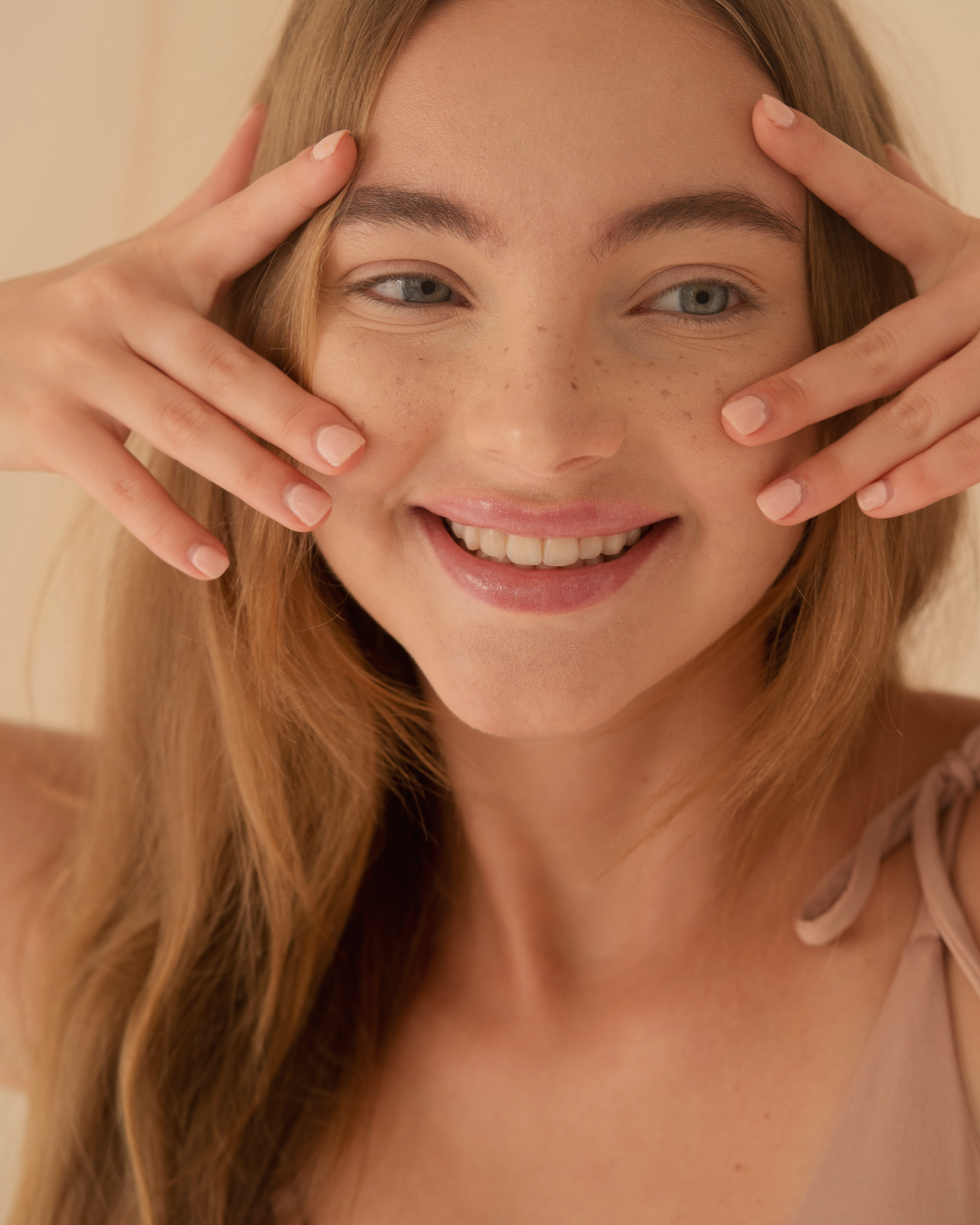 Woman with freckles and even, glowing skin after a pigmentation brightening peel in Canberra